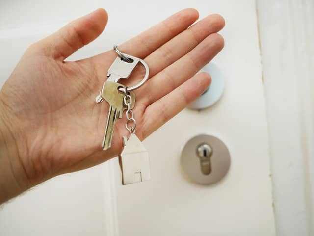 hand holding house key chain