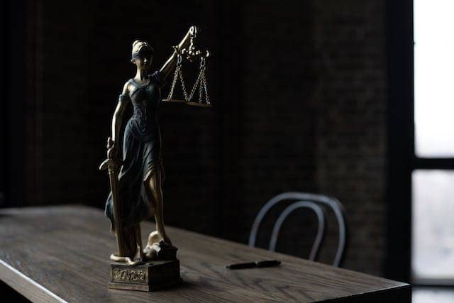 A statue of Lady Justice on a wooden table