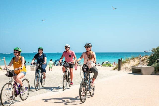 four tourists on a beach bike ride